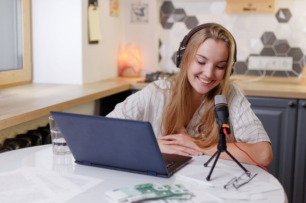 Blonde woman wearing headphones with microphone learning online training class